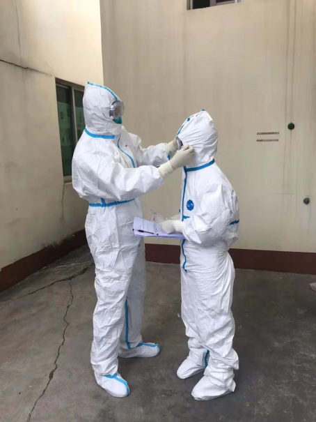 進入隔離病房之前，陳景山為譚秋濃整理防護服
