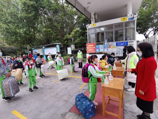 已處理10  沙坪六小的同學(xué)們保持1米線距離在校門口進行手部消毒，有序進校園.jpg